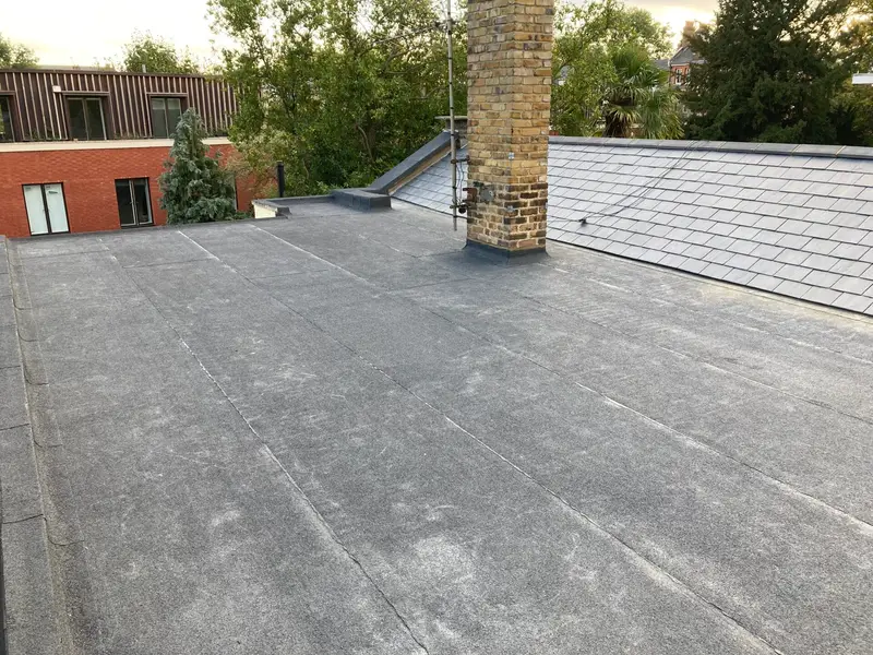 Finished felt flat roof beside a slate roof