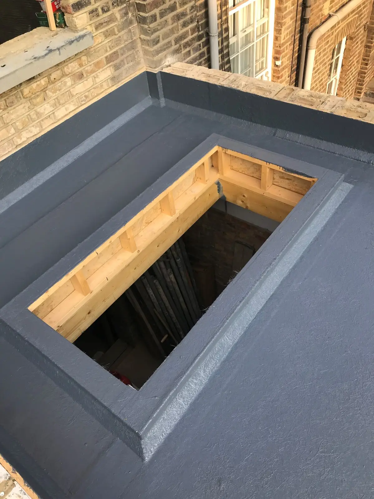 Liquid-applied upstand around a rooflight opening