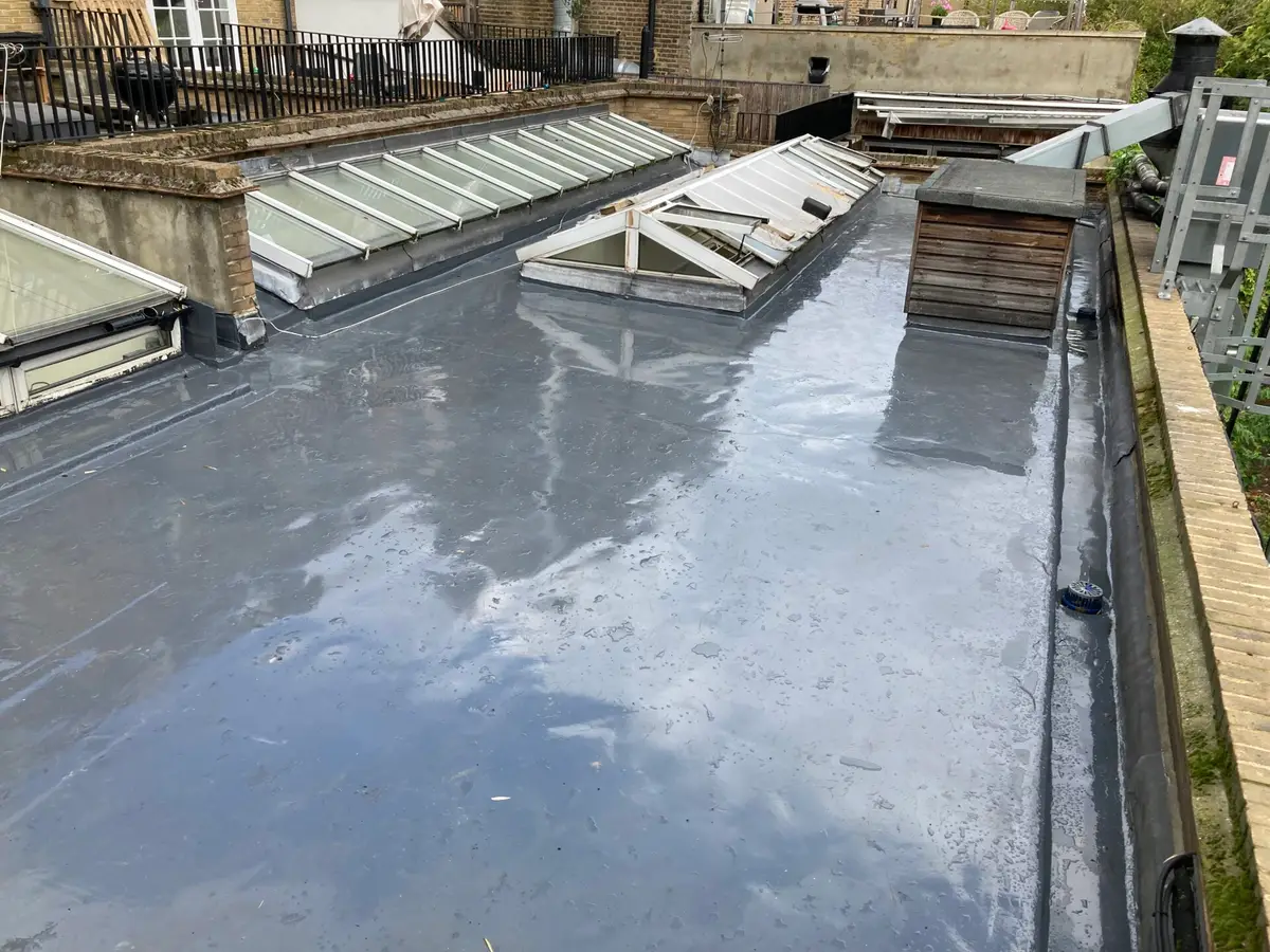 Liquid-applied flat roof beside rooflights