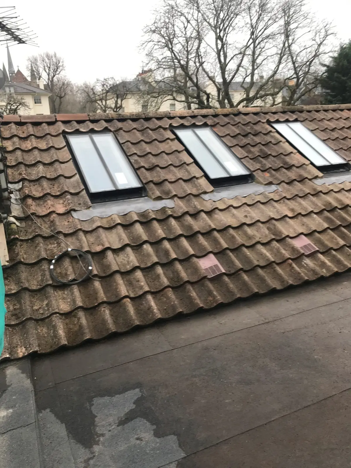 Three roof windows in a clay tile roof